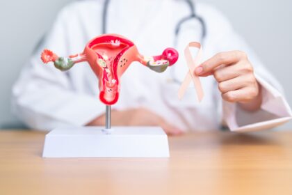 Doctor holding Peach ribbon with Uterus and Ovaries model for September Uterine Cancer Awareness