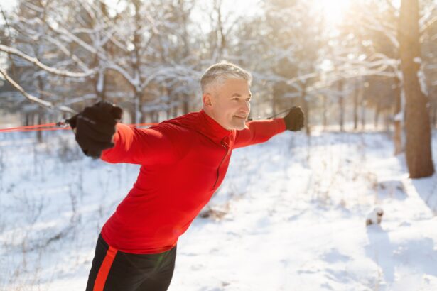 Outdoor winter sports. Happy senior man training with fitness straps at sunny snowy park, free space